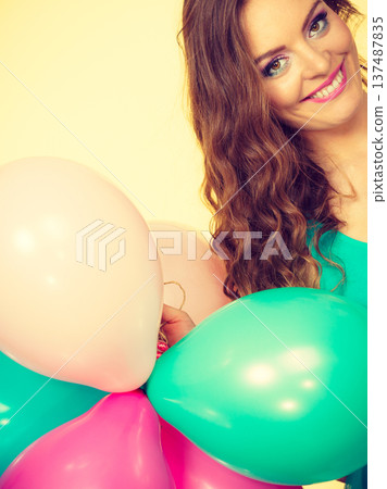 Woman holding bunch of colorful balloons Woman holding bunch of colorful balloons 137487835