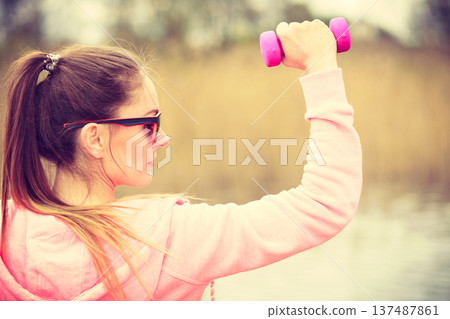 Woman exercising with dumbbells outdoor 137487861