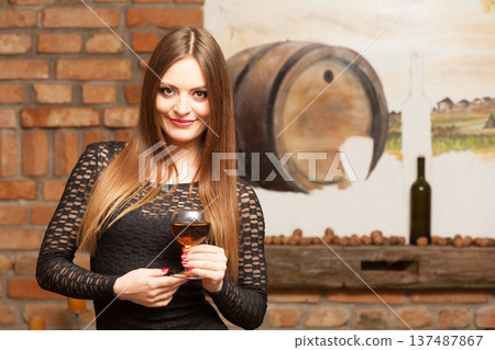 Woman tasting wine in rural cottage interior Woman tasting wine in rural cottage interior 137487867
