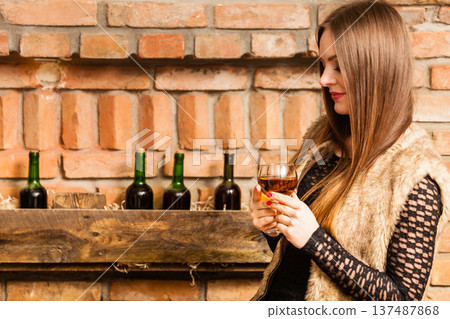 Woman tasting wine in rural cottage interior Woman tasting wine in rural cottage interior 137487868
