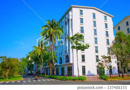 Resort street with apartment building with palm trees on blue sky tropical. Reidential building 137488153