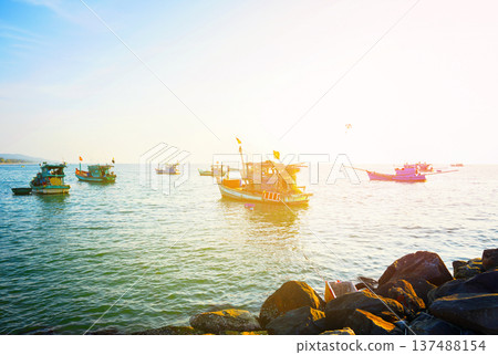 Fishing boats at shore on sunrise. Fishermen's boats in sea at shore in fishing village Fishing boats at shore on sunrise. Fishermen's boats in sea at shore in fishing village 137488154