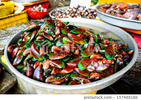Fresh mussels displayed at market stall in coastal town in busy fishing area. Fresh mussels displayed at market stall in coastal town in busy fishing area. 137488166