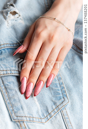 Woman's hand with stiletto nails on denim jacket Woman's hand with stiletto nails on denim jacket 137488201