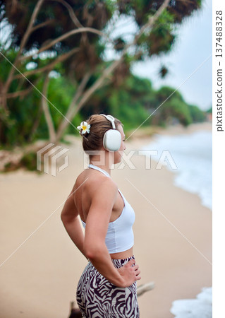 Woman In Summer Resort Attire. Relaxed Summer Style Showcased Amidst Vibrant Green Palm Leaves Woman In Summer Resort Attire. Relaxed Summer Style Showcased Amidst Vibrant Green Palm Leaves 137488328