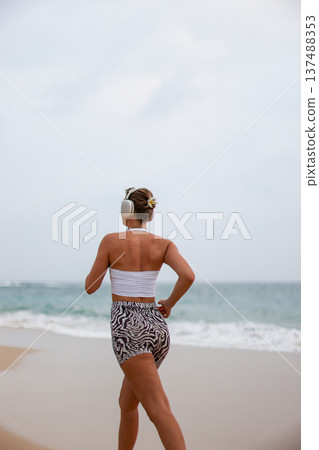 Runner On Beach. Dedicated Athlete Practices Endurance By Jogging Solitary Along Tranquil Ocean Coast Runner On Beach. Dedicated Athlete Practices Endurance By Jogging Solitary Along Tranquil Ocean Coast 137488353