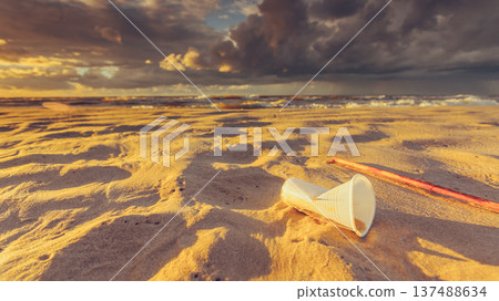 Plastic disposable cup on sea shore. Earth ecology 137488634