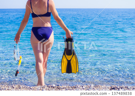 Woman with flippers snorkeling tube on beach Woman with flippers snorkeling tube on beach 137489838