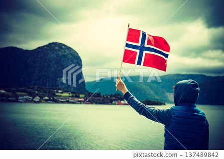 Tourist with norwegian flag on fjord 137489842