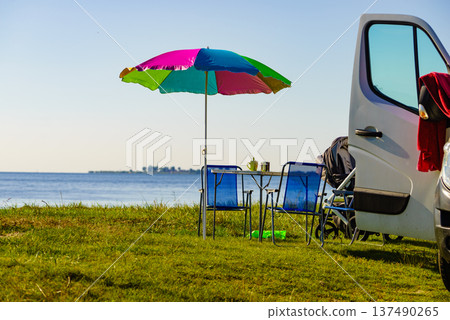 Umbrella with chairs at campervan on beach Umbrella with chairs at campervan on beach 137490265