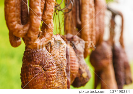 Smoked sausages meat hanging in smokehouse 137490284