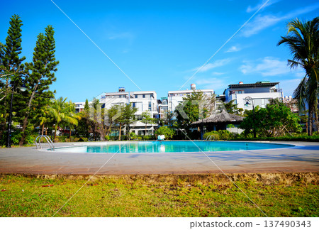 Swimming pool with turquoise water surrounded by dreamy beach hotel buildings Swimming pool with turquoise water surrounded by dreamy beach hotel buildings 137490343