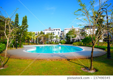 Swimming pool with turquoise water surrounded by dreamy beach hotel buildings Swimming pool with turquoise water surrounded by dreamy beach hotel buildings 137490345