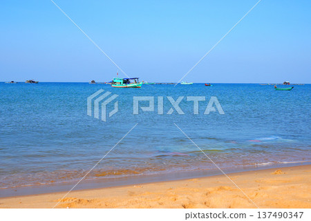 Fishing boat in sea on blue sky. View on ocean from beach. Fishing boats in sea along shore. Fishing boat in sea on blue sky. View on ocean from beach. Fishing boats in sea along shore. 137490347