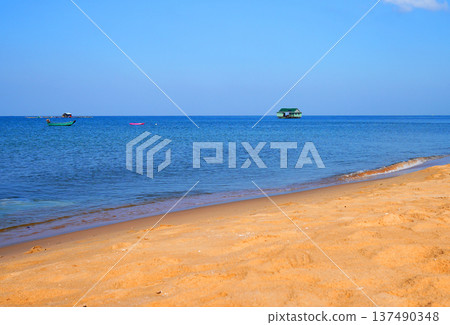 Fishing boat in sea on blue sky. View on ocean from beach. Fishing boats in sea along shore. 137490348