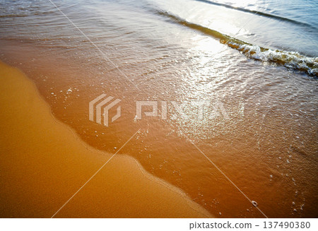 Waves at sea on dramatic sunset background. Sea waves at beach. Waves on sea in calm weather Waves at sea on dramatic sunset background. Sea waves at beach. Waves on sea in calm weather 137490380