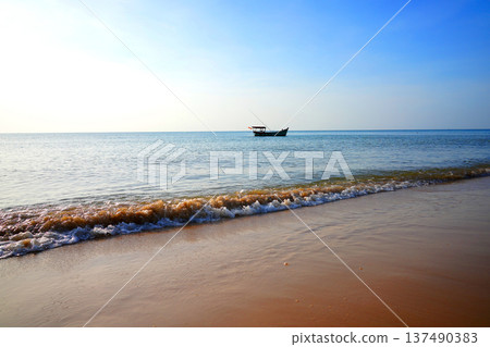Fishing boat in calm ea near sandy beach in bright sunny day, clear blue sky. Fishing boat rests Fishing boat in calm ea near sandy beach in bright sunny day, clear blue sky. Fishing boat rests 137490383