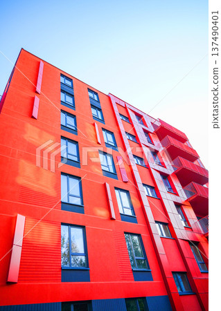 Facade building. Modern brick building with windows on blue sky and bright colors during day.  137490401