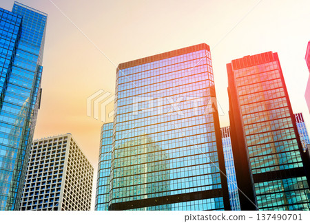 Skyscrapers in bright glass exteriors sunlight on sunset. Modern facade office buildings Skyscrapers in bright glass exteriors sunlight on sunset. Modern facade office buildings 137490701