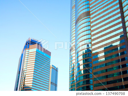 Skyscrapers in bright glass exteriors sunlight on sunset. Modern facade office buildings Skyscrapers in bright glass exteriors sunlight on sunset. Modern facade office buildings 137490708