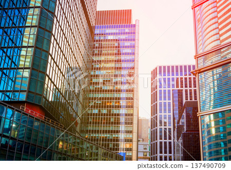 Skyscrapers in bright glass exteriors sunlight on sunset. Modern facade office buildings Skyscrapers in bright glass exteriors sunlight on sunset. Modern facade office buildings 137490709