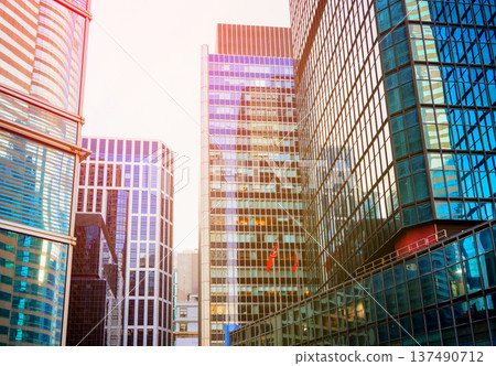 Skyscrapers in bright glass exteriors sunlight on sunset. Modern facade office buildings Skyscrapers in bright glass exteriors sunlight on sunset. Modern facade office buildings 137490712