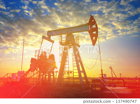 Pumpjack in oil well of oil field on sunrise in Industrial crude area. Crude pump jack on oil field Pumpjack in oil well of oil field on sunrise in Industrial crude area. Crude pump jack on oil field 137490747