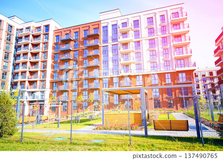 Facade building. Block house with playground in closed courtyard. Cityscape of residential area 137490765