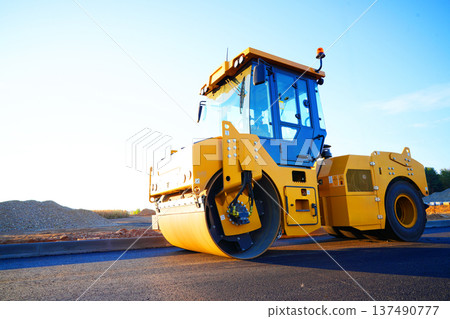 Road Asphalting construction. Asphalt paving repair. Vibrator compactor machine on roadworks 137490777