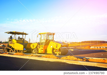 Road Asphalting construction. Asphalt paving repair. Vibrator compactor machine on roadworks 137490780