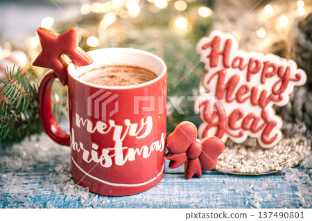 Christmas red cup with the inscription Merry Christmas on a blurred background with lights close up. Christmas red cup with the inscription Merry Christmas on a blurred background with lights close up. 137490801