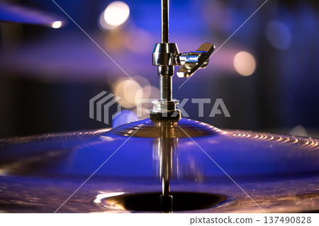 Drum cymbal close-up on a dark blurred background. Drum cymbal close-up on a dark blurred background. 137490828