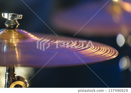 Drum cymbal close-up on a dark blurred background. Drum cymbal close-up on a dark blurred background. 137490829