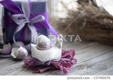 Easter composition with an egg and a gift on a blurred background. 137490876