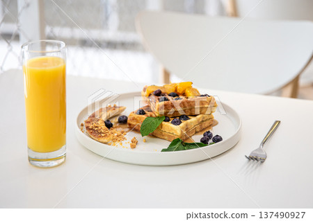 Delicious Belgian waffles with berries and fruits and a glass of juice. 137490927