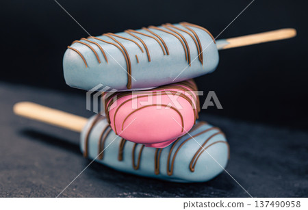 Dessert in the form of popsicle ice cream covered with pink and blue chocolate. Dessert in the form of popsicle ice cream covered with pink and blue chocolate. 137490958