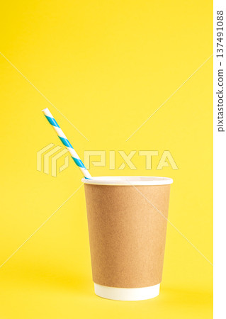 Disposable cup with a straw on a yellow background isolated. 137491088