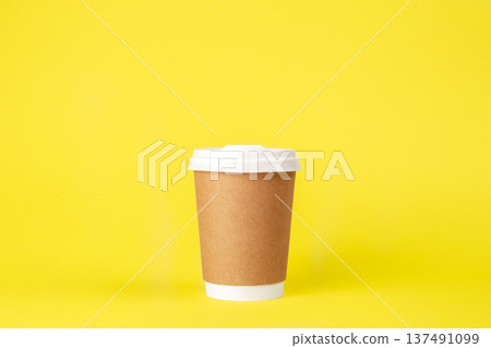 Disposable paper cup on a yellow background isolated. 137491099
