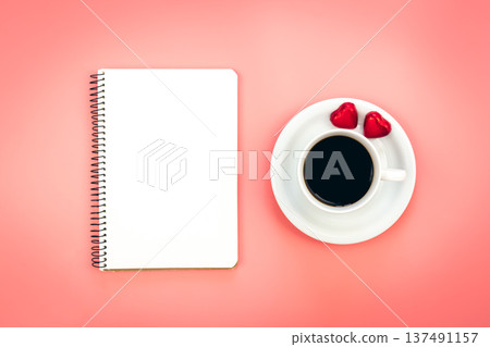A cup of coffee, a blank notepad and heart shaped candies, top view. 137491157