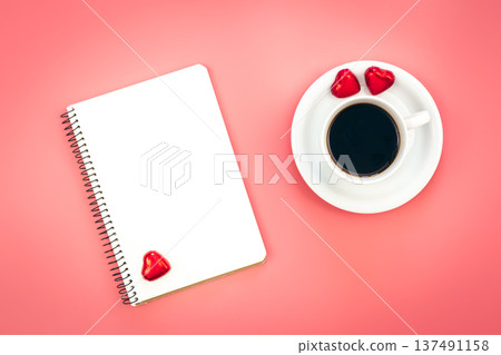 A cup of coffee, a blank notepad and heart shaped candies, top view. A cup of coffee, a blank notepad and heart shaped candies, top view. 137491158