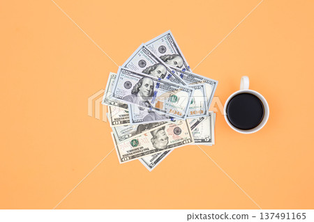 Cup of coffee and dollar bills on a orange background, flat lay. 137491165