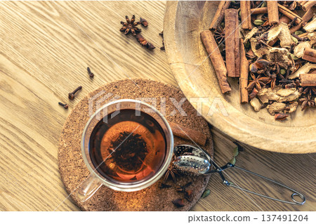 Cup of freshly brewed black tea, different types of spices on wooden table. Cup of freshly brewed black tea, different types of spices on wooden table. 137491204