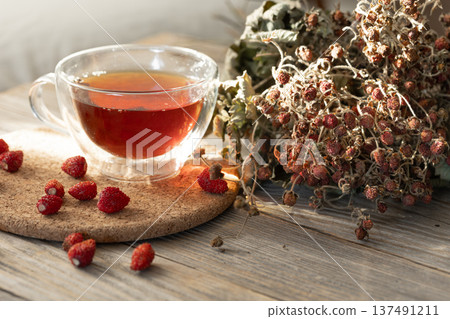 A cup of natural tea and wild strawberries, rustic still life. A cup of natural tea and wild strawberries, rustic still life. 137491211