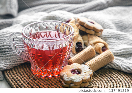 A cup of red tea and cookies on a blurred background with a knitted element. A cup of red tea and cookies on a blurred background with a knitted element. 137491219