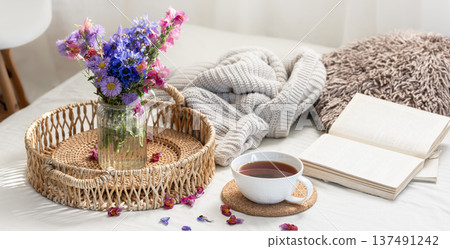 Cup of tea, a bouquet of wildflowers, book and knitted element. Cup of tea, a bouquet of wildflowers, book and knitted element. 137491242