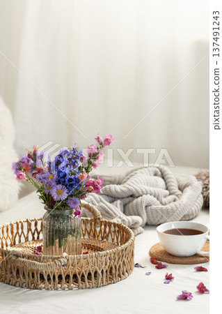 Cup of tea, a bouquet of wildflowers, book and knitted element. Cup of tea, a bouquet of wildflowers, book and knitted element. 137491243