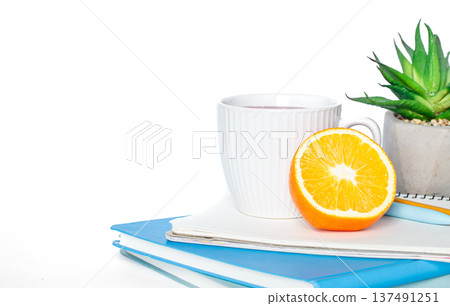 A cup of tea, notebooks on a white background isolated, copy space. A cup of tea, notebooks on a white background isolated, copy space. 137491251