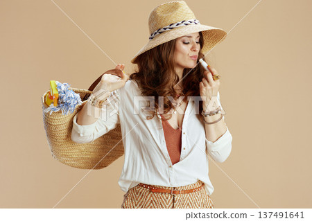 housewife in blouse and shorts against beige 137491641