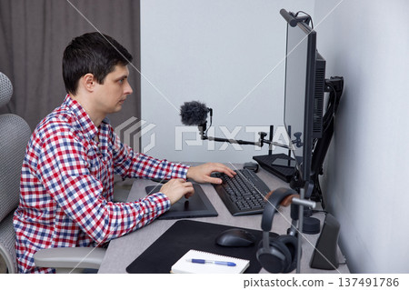 Man using computer and graphic tablet for his remote work at home office Man using computer and graphic tablet for his remote work at home office 137491786