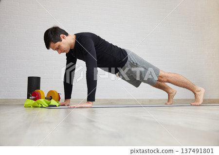 Man doing strength training on mat, focusing on core muscles 137491801